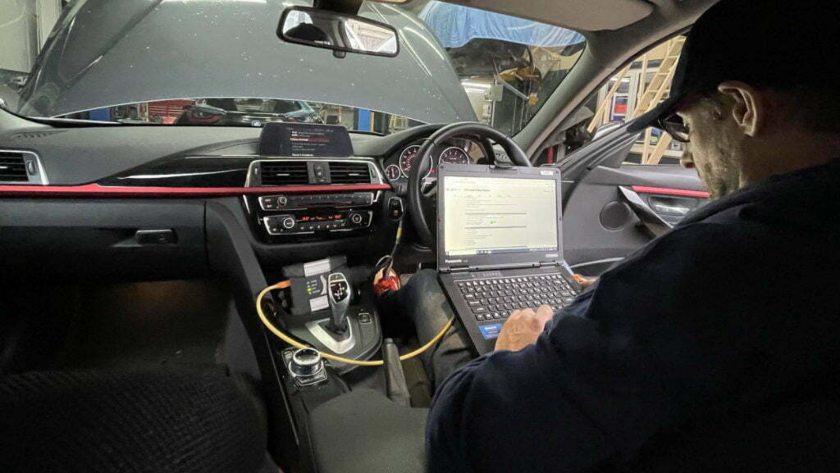 Technician on laptop in vehicle